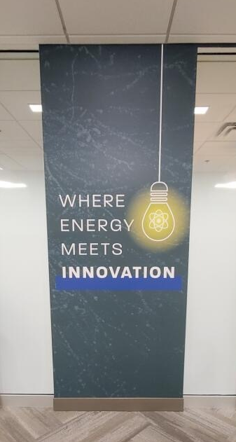 A panel showing an illustration of a glowing light bulb and the title of the installation, "Where Energy Meets Innovation."