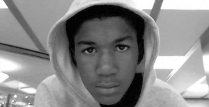 Trayvon Martin, wearing a gray hoodie, gazes straight into the camera.