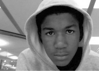 Trayvon Martin, wearing a gray hoodie, gazes straight into the camera.